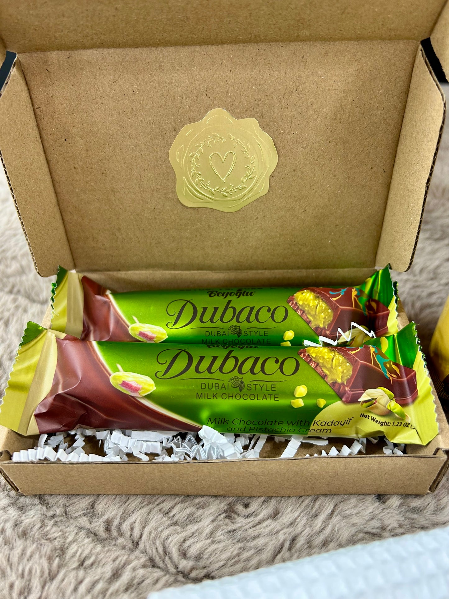 Dubaco Dubai chocolate bars in a cardboard box with a visible brand logo.